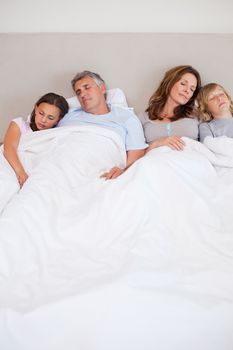 Family sleeping in the bedroom together