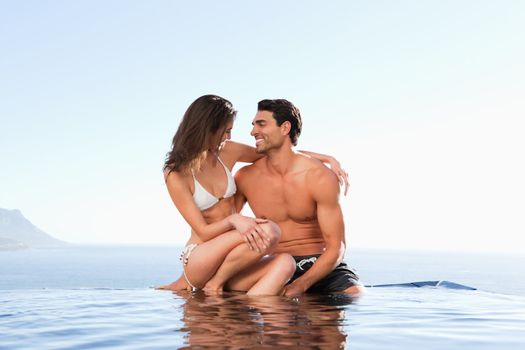 Couple sitting on the pool edge together
