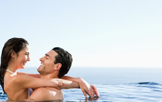 Young couple embracing in the pool