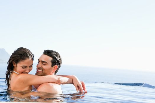 Young couple hugging in the pool