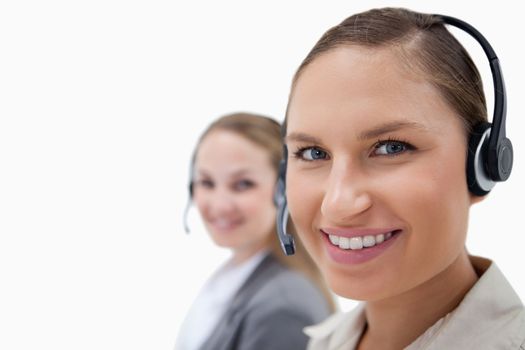 Young female operators using headsets against a white background