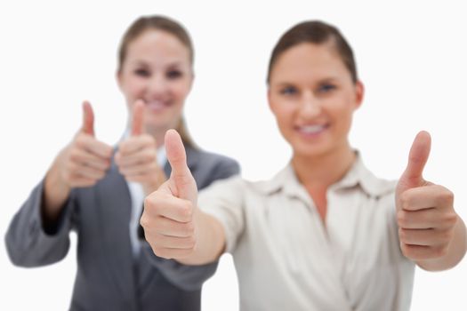 Happy businesswomen posing with the thumb up against a white background