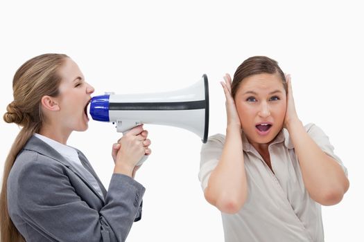 Businesswoman yelling at her coworker through a megaphone against a white background