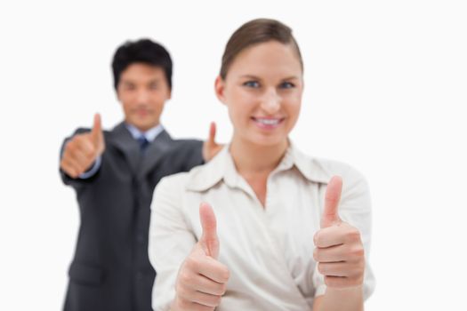 Smiling business people with the thumbs up against a white background
