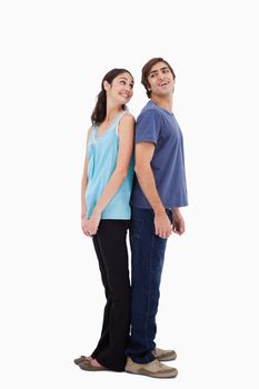 Portrait of a smiling couple standing back to back against a white background
