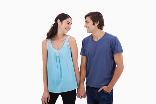 Young couple holding hands against a white background