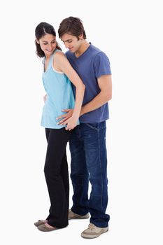 Portrait of a man embracing his girlfriend against a white background