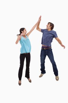 Portrait of a couple jumping together against a white background