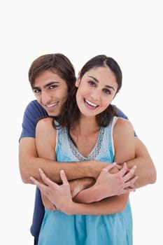 Portrait of a charming couple embracing each other against a white background