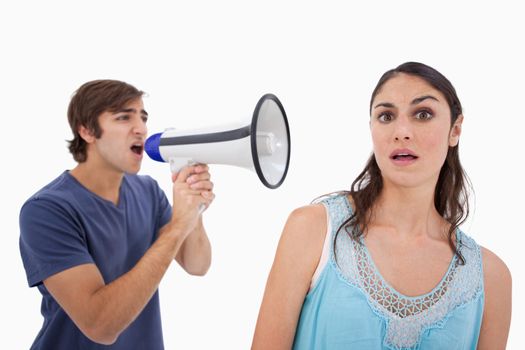 Man yelling at her girlfriend through a megaphone against a white background