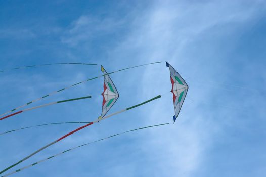 Two kites flying in the blue sky