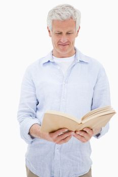 Portrait of a man reading a book against a white background