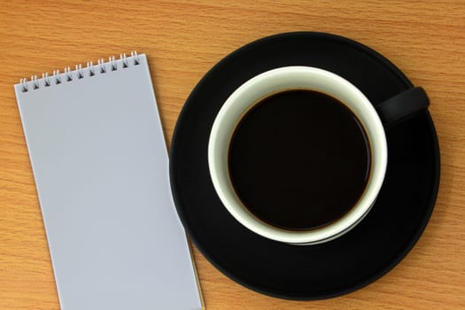 Coffee cup and white notebook