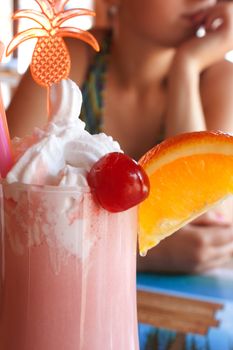 milkshake with a cherry and orange on the glass in the cafe shooting