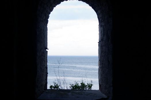 Sea view through the window of an old stone fortress photography