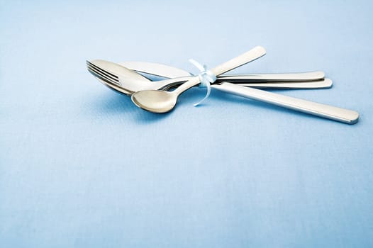 A silver wear set on blue tablecloth