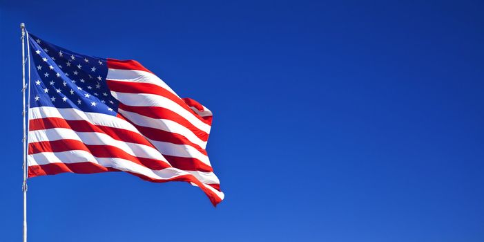 American flag fluttering in the blue sky