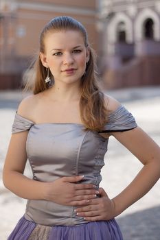 Portrait of a girl in a dress on a background of the city