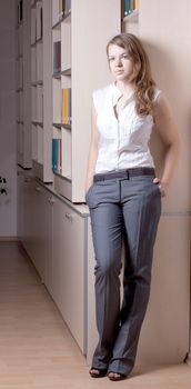 Beautiful girl in the library among the books