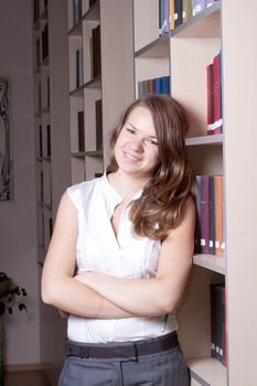 Beautiful girl in the library among the books