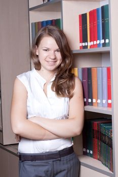 Beautiful girl in the library among the books