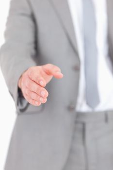 Portrait of a masculine hand ready for a handshake against a white background