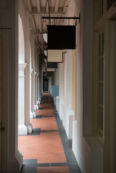 Passage in old classical building with shops' signboards