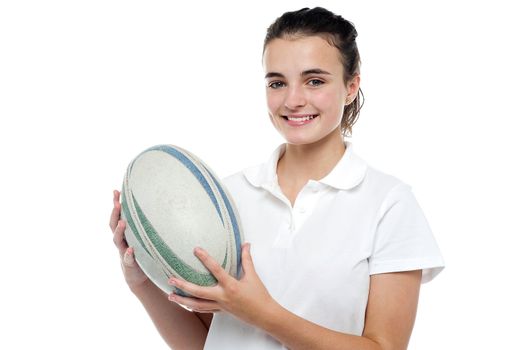 Attractive sporty girl posing with rugby ball isolated over white background