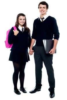Full length portrait of students in uniform ready to go school with backpack and files