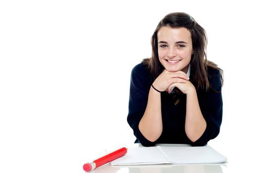 Attractive confident young schoolgirl posing in front of camera