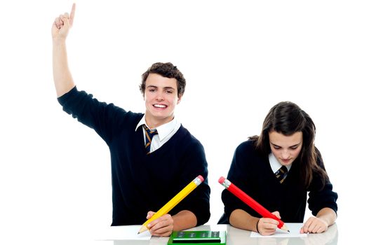 I am done with the test. Boy raises his hand while the girl is still busy writing