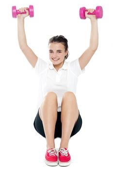Young girl sitting on floor and doing fitness exercise. All on white background