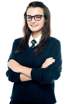 Profile shot of pretty bespectacled teenager posing with crossed arms