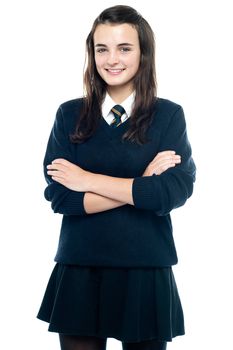 Pretty smiling teenager looking at you confidently. Arms folded