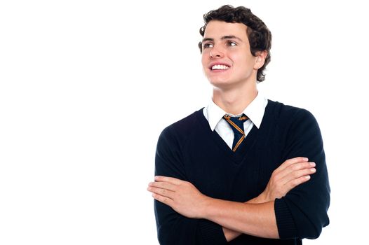 An attentive youngster looking at the board with his arms crossed