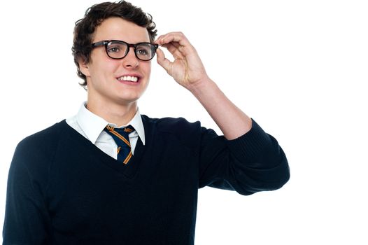 Smiling student adjusting his spectacles while looking far away