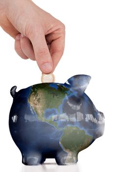 Hand inserting a coin in a piggy bank against a white background. 