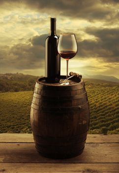 red wine bottle and wine glass on wooden barrel