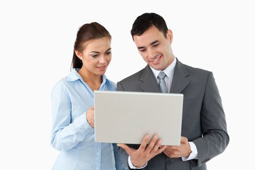 Business partners looking at laptop together against a white background