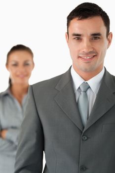 Close up of smiling businessman with colleague behind him against a white background