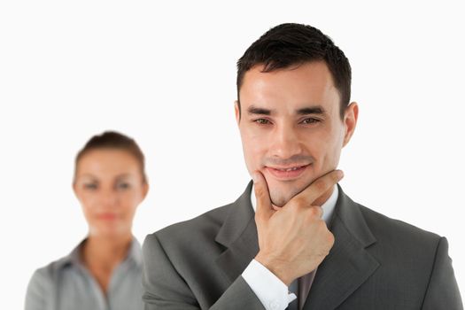 Close up of confident businessman with colleague behind him against a white background