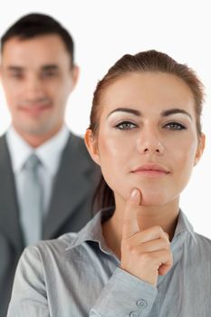 Close up of thinking businesswoman with colleague in the background against a white background