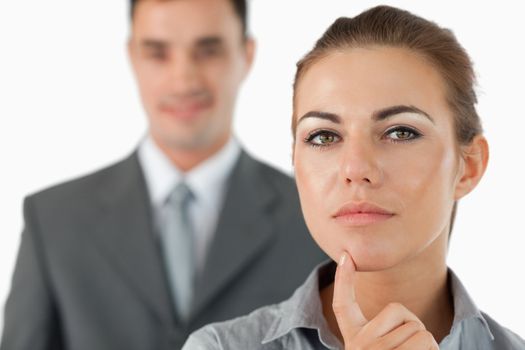 Close up of thinking businesswoman with colleague behind her against a white background