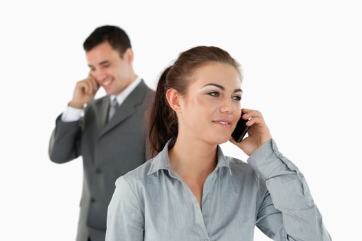 Close up of business partners talking on the phone against a white background