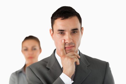 Close up of young businessman with colleague behind him against a white background