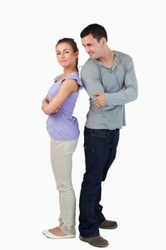 Young couple standing back-to-back to each other against a white backgrounf
