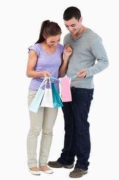 Young couple looking at their shopping against a white background
