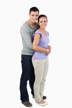 Side view of young male holding his girlfriend against a white background