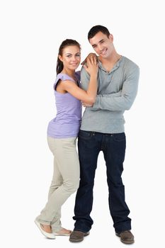 Young couple standing close together against a white abckground