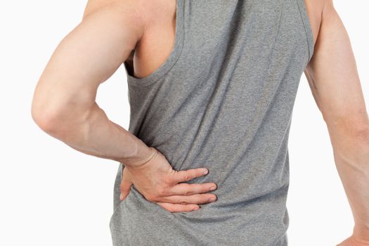 Male hands touching own spine against a white background